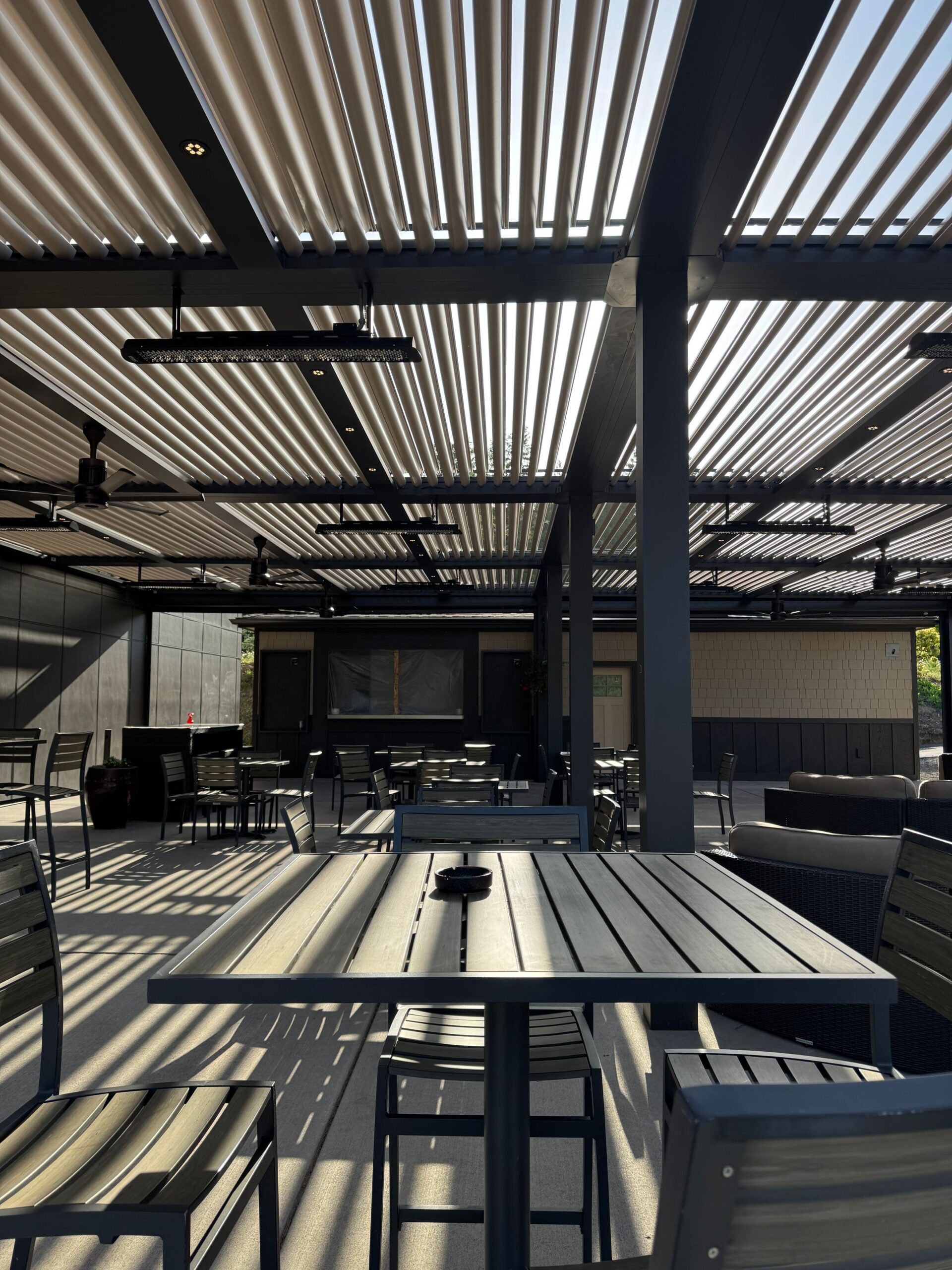 Stor pergola med lamelltak, integrert belysning og serveringsområde