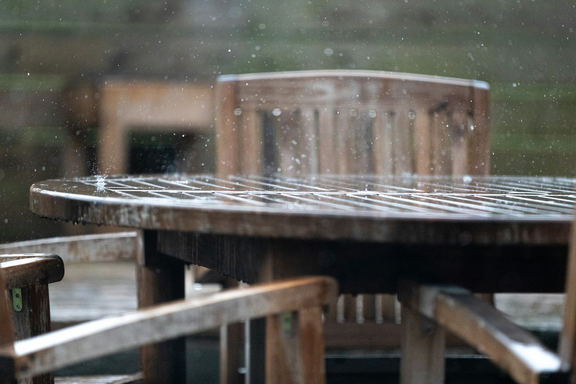 Regndråper som treffer et utebord av tre